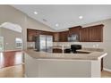 Modern kitchen featuring stainless steel appliances and a breakfast bar overlooking the dining area at 9871 Nonacrest Dr, Orlando, FL 32832