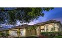Inviting home exterior with lush landscaping, a spacious three-car garage, and a warm, welcoming ambiance at 10030 Chatham Oaks Ct, Orlando, FL 32836