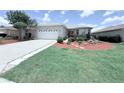 Charming single-story home featuring a well-maintained front yard and a two-car garage at 10075 Sw 91St Pl, Ocala, FL 34481
