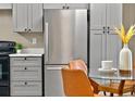 Modern kitchen featuring a stainless steel refrigerator and gray cabinets, next to an adjacent dining area at 10545 Parkway Dr, Clermont, FL 34711
