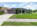 Charming single-story home with a well-manicured lawn and inviting curb appeal under a cloudy sky at 11900 Frieth Dr, Orlando, FL 32837