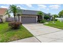 Inviting home with a two car garage, well-manicured lawn, trees and sidewalk leading to front door at 11900 Frieth Dr, Orlando, FL 32837
