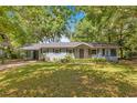 Charming single-story home with a well-maintained lawn, mature trees, and a convenient carport at 12046 Se 135Th Ave, Ocklawaha, FL 32179