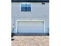 Attached two car garage for a townhome with brick paved driveway at 123 Kenny Blvd, Haines City, FL 33844