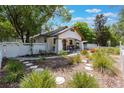 Beautifully landscaped front yard featuring a white picket fence, lush greenery, and a stone path leading to the home at 1505 Magnolia Ave, Sanford, FL 32771