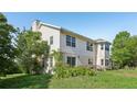Charming home features a large backyard with green grass and a view of a two-story home at 16249 Se 162Nd Ct, Weirsdale, FL 32195