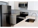 Modern kitchen featuring stainless steel appliances, white cabinets, and stylish countertops at 1800 Coriander Dr, Kissimmee, FL 34759