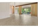 Spacious living room featuring tile floors, large windows, and a decorative chandelier at 200 Maitland Ave # 122, Altamonte Springs, FL 32701