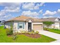 Attractive single-Gathering home displaying a two car garage, pretty landscaping and manicured lawn at 200 Summershore Dr, Auburndale, FL 33823