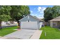 Detached garage and driveway, with green lawn and mature trees, providing ample parking at 202 Twisting Trl, Orlando, FL 32825
