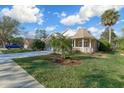 Attractive one-story home with a welcoming front porch, lush lawn, and side-entry garage at 25 Reflections Village Dr, Ormond Beach, FL 32174