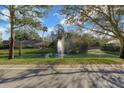 A scenic pond with a central fountain, enhanced by mature trees and landscaping at 25 Reflections Village Dr, Ormond Beach, FL 32174