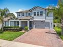 Charming two-story home featuring a well-manicured lawn and a brick driveway leading to a two-car garage at 2676 Estuary Loop, Oviedo, FL 32765