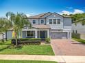 Charming two-story home featuring a well-manicured lawn and a brick driveway leading to a two-car garage at 2676 Estuary Loop, Oviedo, FL 32765