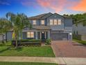 Charming two-story home featuring a well-manicured lawn and a brick driveway leading to a two-car garage at 2676 Estuary Loop, Oviedo, FL 32765