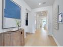 Bright and airy hallway with light wood floors, white walls, and stylish decor at 3118 Norcott Dr, Davenport, FL 33837