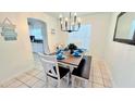 Cozy dining area with a modern chandelier, a wood table, and a bench with stylish decor at 3129 Arrow Dr, Kissimmee, FL 34746