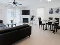 Bright living area with neutral tile flooring, fireplace, modern ceiling fan, and sliding doors to the backyard at 3260 Pinto Dr, Kissimmee, FL 34746