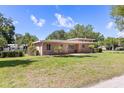 A well-maintained house with a lush green lawn and mature trees at 360 W University Ave, Orange City, FL 32763