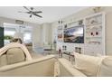 Cozy living room showcasing built-in shelving, comfortable seating, and a ceiling fan at 4002 Richmond Xing, Leesburg, FL 34748