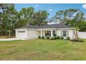 Landscaped front yard of a well-maintained one-story home with a two-car garage at 5 Pecan Drive Crse, Ocala, FL 34472