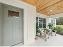 Inviting front porch with wood ceiling, features seating area and a painted front door at 5 Pecan Drive Crse, Ocala, FL 34472