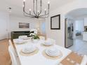 Elegant dining area with modern chandelier, seating for six, and open layout to living area at 5371 Lonesome Dove Dr, Kissimmee, FL 34746