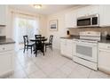 Eat-in kitchen with white appliances and cabinets, granite countertops, and sliding doors to the yard at 5371 Lonesome Dove Dr, Kissimmee, FL 34746