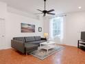 Bright living room features a large window, sleek gray sofa and stylish decor at 5371 Lonesome Dove Dr, Kissimmee, FL 34746