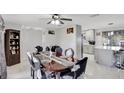 Elegant dining room boasts a modern ceiling fan, dark wood table with seating for six, and opens to the kitchen at 7 Madeira Ave, Orlando, FL 32825