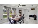 Bright dining room with a dark wood table, chairs, and a large window offering natural light at 7 Madeira Ave, Orlando, FL 32825