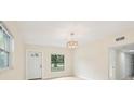 Bright, open living room with a decorative chandelier, tile flooring, and a front-facing window at 7301 Armstrong Rd, Orlando, FL 32810