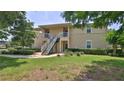 Inviting two-story condo with lush landscaping and stairs leading to the second level at 830 Airport Rd # 115, Port Orange, FL 32128