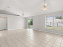 Spacious living room with neutral paint, tiled floors, ceiling fans, and sliding doors to the backyard at 831 Lindley Blvd, Deland, FL 32724