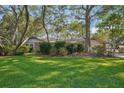 A lush green front yard featuring mature trees and established landscaping at 921 Torchwood Dr, Deland, FL 32724