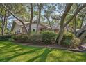 Spacious front yard surrounded by mature trees and established landscaping at 921 Torchwood Dr, Deland, FL 32724