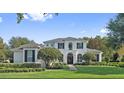 Charming white home with arched entryway, brick walkway, and meticulously maintained landscaping at 968 Ashton Oaks Cir, Lakeland, FL 33813