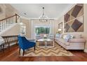 Inviting living room with hardwood floors, modern chandelier, and comfortable seating arrangement at 968 Ashton Oaks Cir, Lakeland, FL 33813