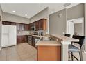 Efficient kitchen with dark wood cabinetry, stainless steel appliances, and breakfast bar at 6404 S Goldenrod Rd # A, Orlando, FL 32822