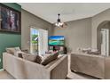 Cozy living room features neutral paint, a ceiling fan, and balcony access at 6404 S Goldenrod Rd # A, Orlando, FL 32822