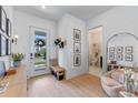 Bright foyer featuring light wood floors, modern decor, stylish seating, and access to a powder room at 10183 Peebles St, Orlando, FL 32827