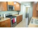 Well-lit kitchen with stainless steel appliances, light countertops, and wooden cabinetry at 110 N Alderwood St, Winter Springs, FL 32708