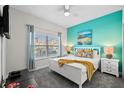 Bright bedroom with a colorful accent wall, stylish furnishings, and natural light from the window at 1128 Challenge Dr, Davenport, FL 33896