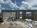 The shell of the house is under construction with a clear blue sky and clouds in the background at 1153 Basalt Ln, Sanford, FL 32771