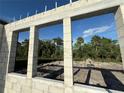 View through window framing reveals blue sky, trees, and newly graded soil outside the house at 1153 Basalt Ln, Sanford, FL 32771