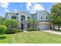 Charming two-story home with a manicured lawn, complemented by lush landscaping and a two car garage at 1467 Selbydon Way, Winter Garden, FL 34787