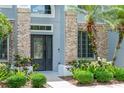 Close up on a charming front entrance with brick accents and lush landscaping with palm trees at 1467 Selbydon Way, Winter Garden, FL 34787