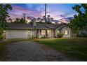 Charming single-Gathering home featuring a brick and white exterior, well-maintained lawn, and attached garage at 2040 E Triangle Dr, Longwood, FL 32779