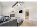 Bright living room features a decorative fireplace, ceiling fan, and a comfortable black leather couch at 2040 E Triangle Dr, Longwood, FL 32779