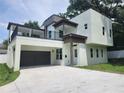 Modern two-story home with a balcony, covered parking, and manicured lawn at 21 N Hampton Ave # Lot 2, Orlando, FL 32803
